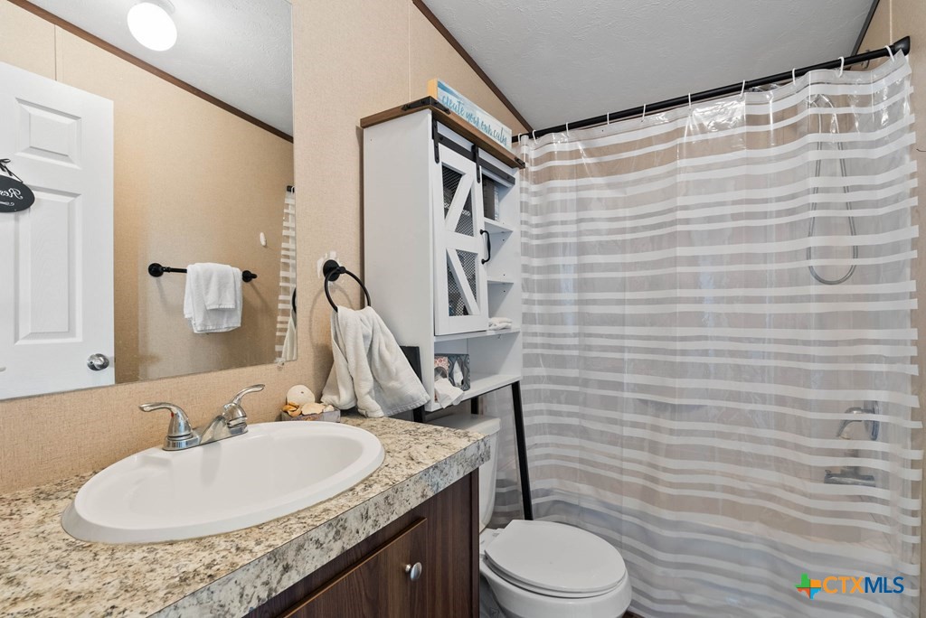 239 Allen M Parks Drive Rockport, TX 78382 - Photo 12 of 29 a bathroom with a granite countertop sink toilet and shower
