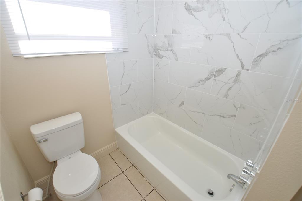 1445 East Stuart Street Bartow, FL 33830 - Photo 11 of 18 a white toilet sitting next to a bath tub