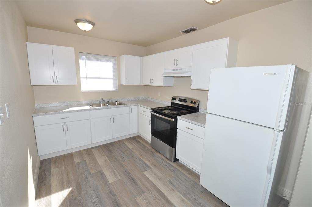 1445 East Stuart Street Bartow, FL 33830 - Photo 4 of 18 a kitchen with cabinets appliances a sink and a window
