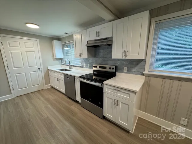 a kitchen with a stove sink and cabinets