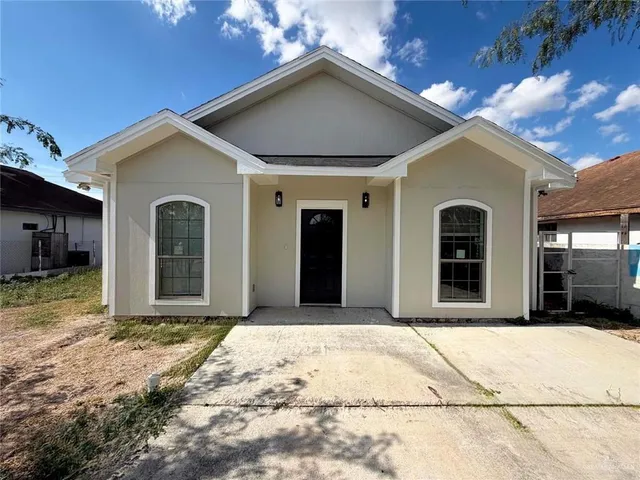 a view of yellow house with wooden fence
