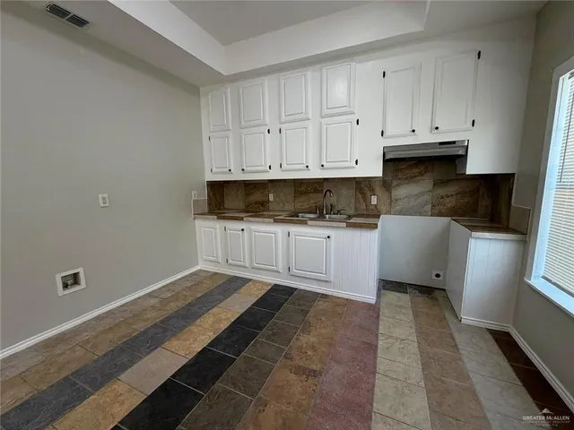 a kitchen with granite countertop white cabinets and stainless steel appliances