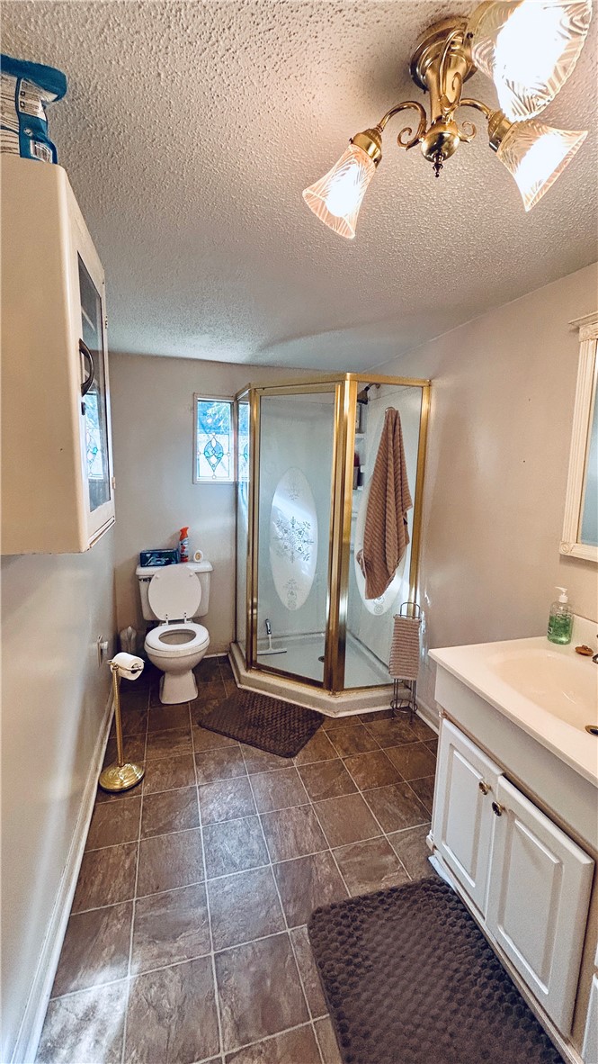 608 29 N Bypass Anderson, SC 29621 - Photo 13 of 20 A compact bathing area featuring a corner shower with a decorative glass door and a single vanity.
