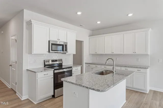 a kitchen with a sink stove and cabinets
