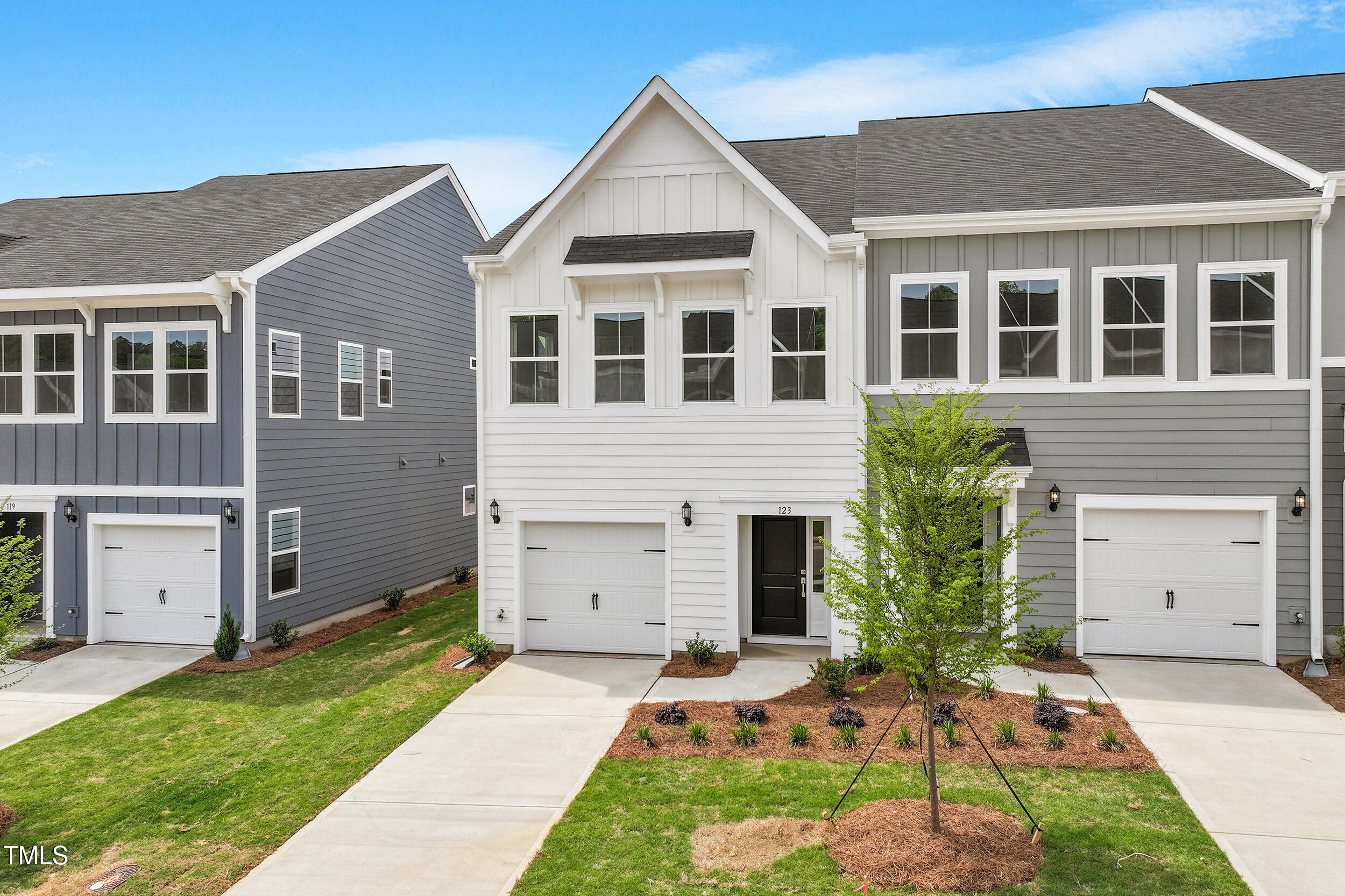 123 Powell Townes Way, Unit 302 Raleigh, NC 27603 - Photo 2 of 44 a front view of a house with a yard and garage