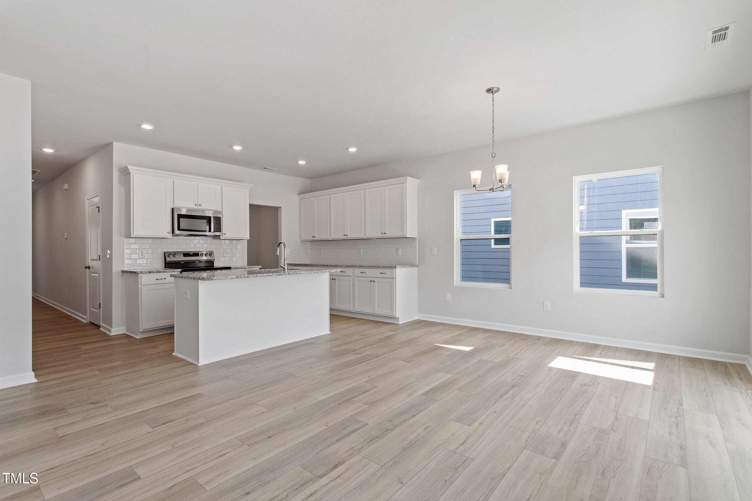 123 Powell Townes Way, Unit 302 Raleigh, NC 27603 - Photo 9 of 44 a view of kitchen with granite countertop stainless steel appliances sink and microwave