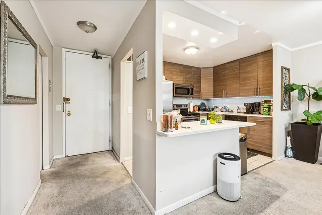 a kitchen with stainless steel appliances kitchen island granite countertop a refrigerator and a sink