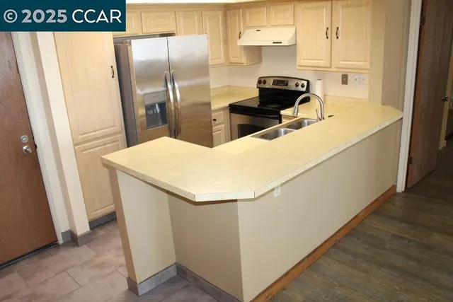 a kitchen with stainless steel appliances a refrigerator and a stove