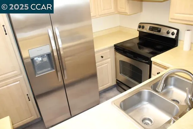 a view of a kitchen with fridge and wooden floor