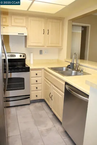 a kitchen with a stove sink and cabinets