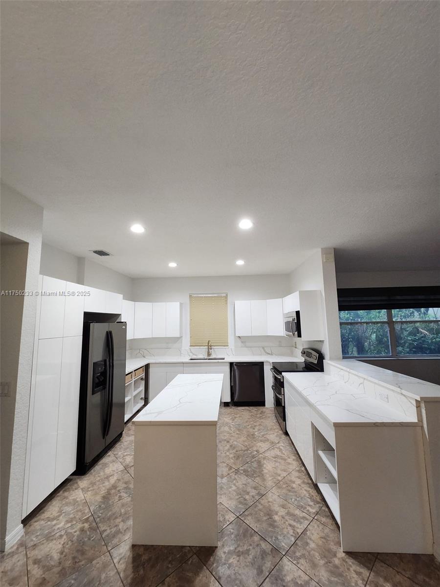 Mission Bay Boca Raton, FL 33498 - Photo 11 of 13 a large living room with stainless steel appliances kitchen island granite countertop a large counter top stainless steel appliances and cabinets