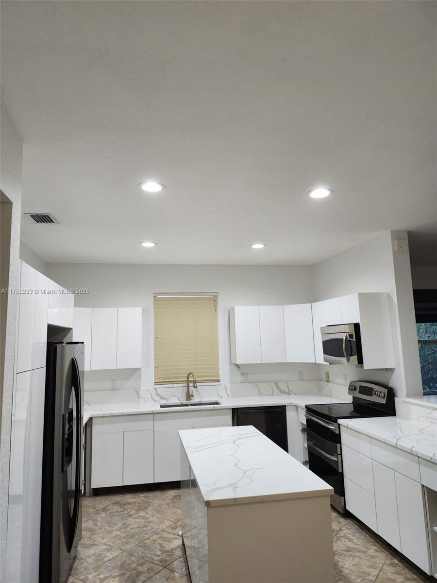 Mission Bay Boca Raton, FL 33498 - Photo 12 of 13 a large kitchen with a large window and stainless steel appliances