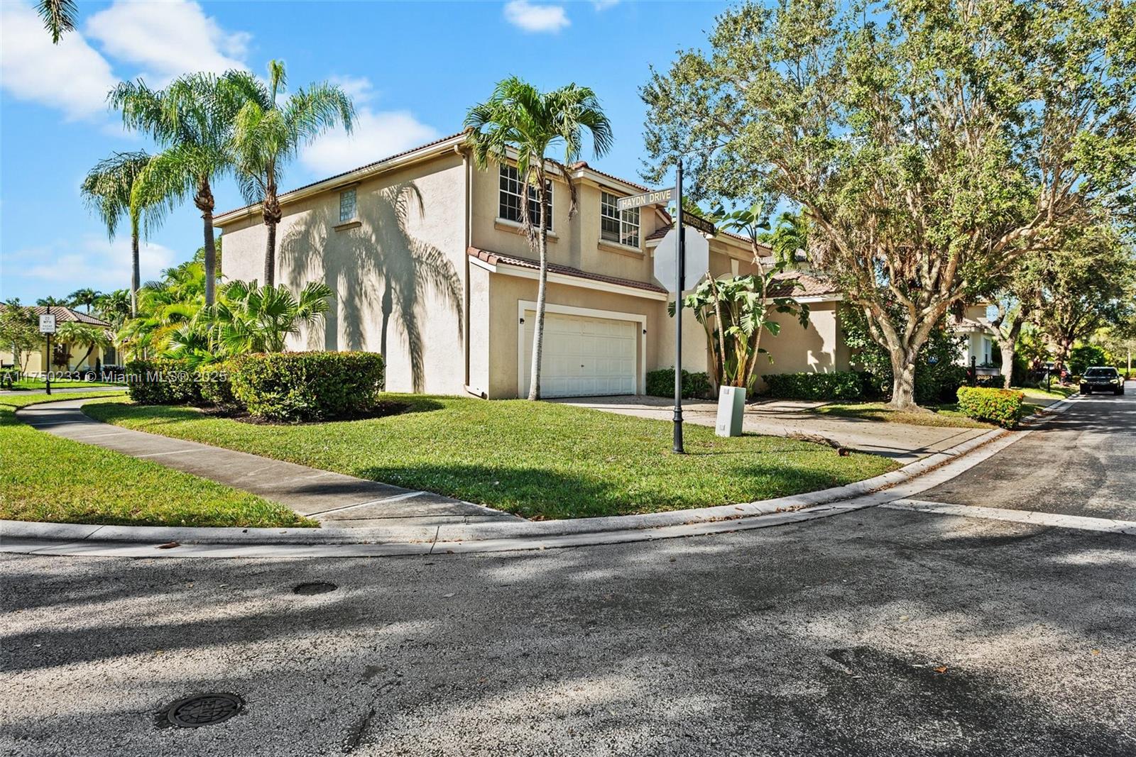 Mission Bay Boca Raton, FL 33498 - Photo 2 of 13 a front view of a house with a yard and a garage