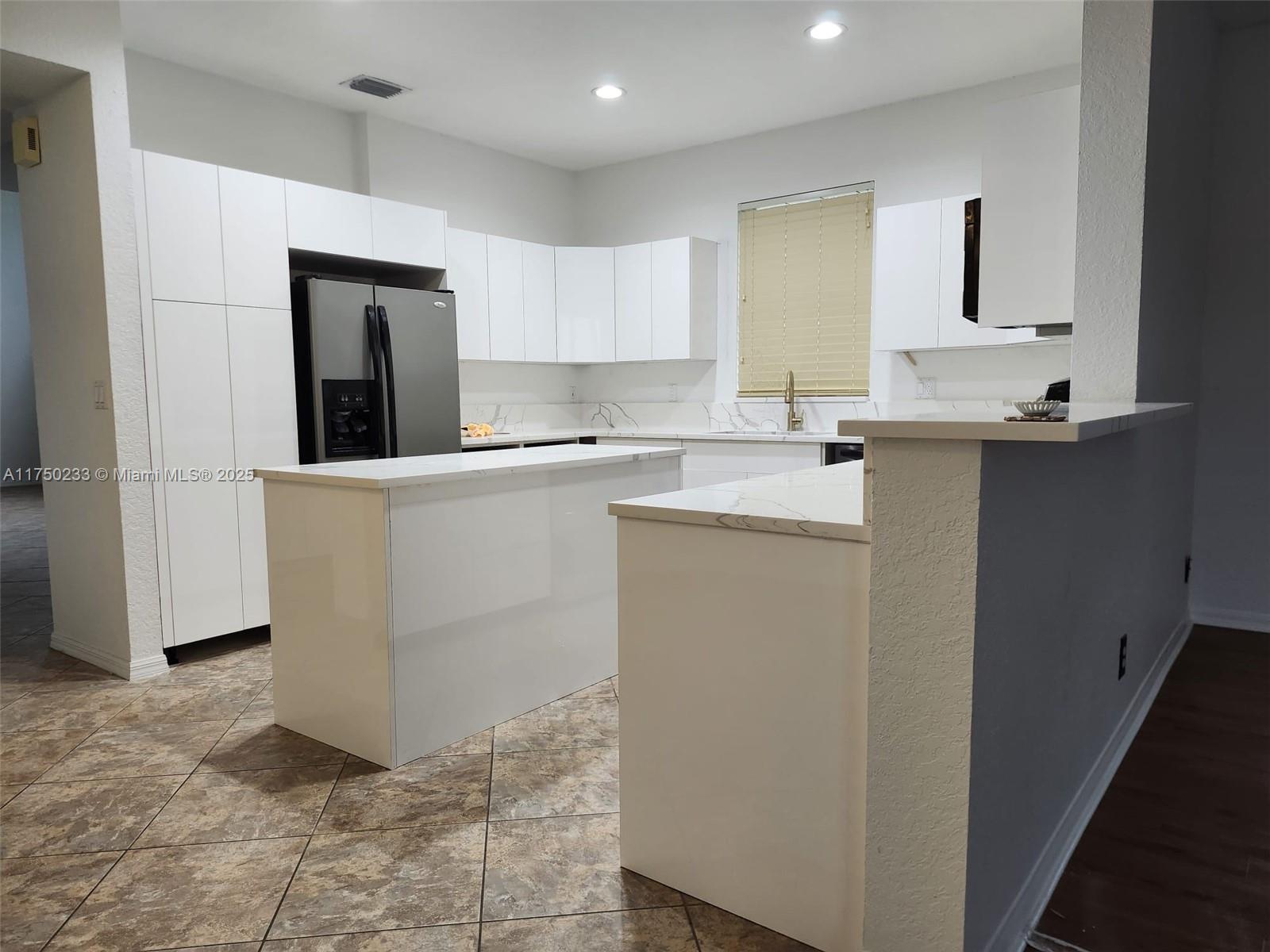 Mission Bay Boca Raton, FL 33498 - Photo 10 of 13 a kitchen with a sink a refrigerator and cabinets
