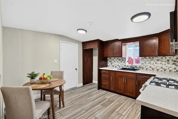a kitchen with granite countertop a table chairs stove and cabinets