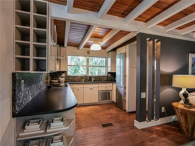a kitchen with a table chairs refrigerator and window