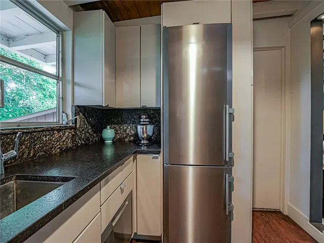 a kitchen with stainless steel appliances granite countertop a refrigerator and a sink