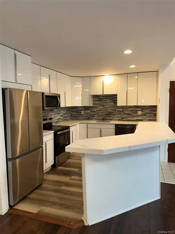 a kitchen with stainless steel appliances a refrigerator stove microwave and cabinets