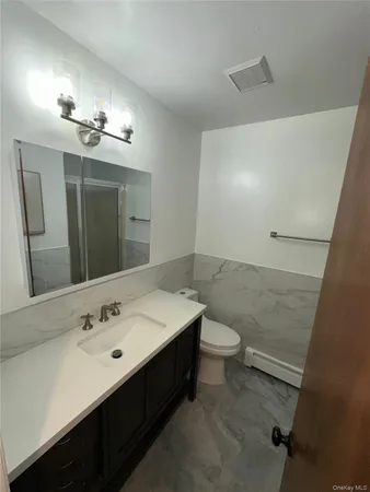 a bathroom with a double vanity sink toilet and mirror