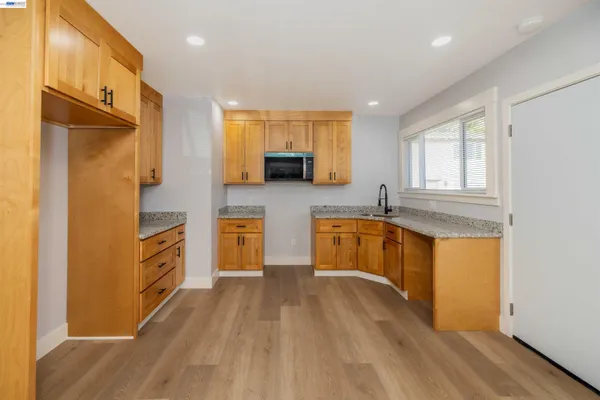 a kitchen with stainless steel appliances granite countertop a stove a sink and a microwave
