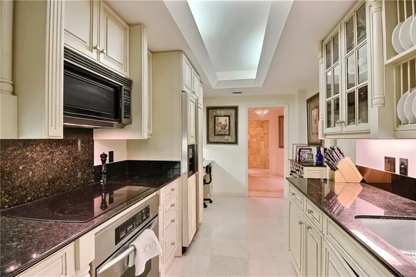 a kitchen with granite countertop a sink and a stove top oven