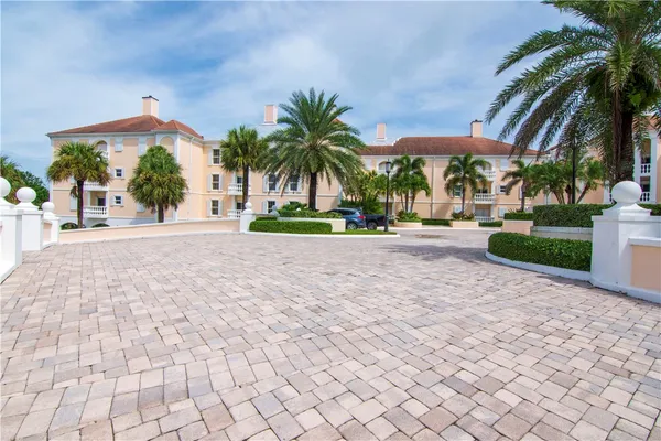 a palm tree sitting in front of a building with yard