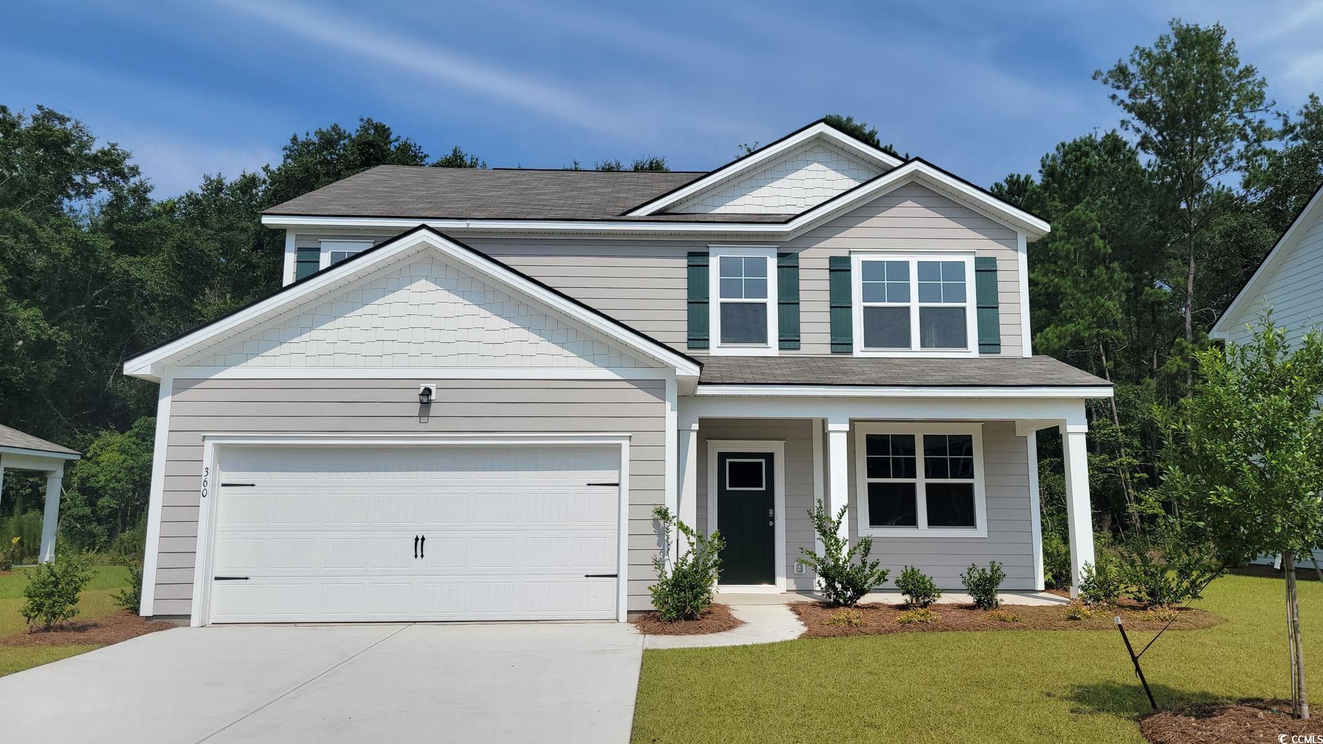 View of front of property with concrete driveway, a front yard, a garage, covered porch, and roof with shingles