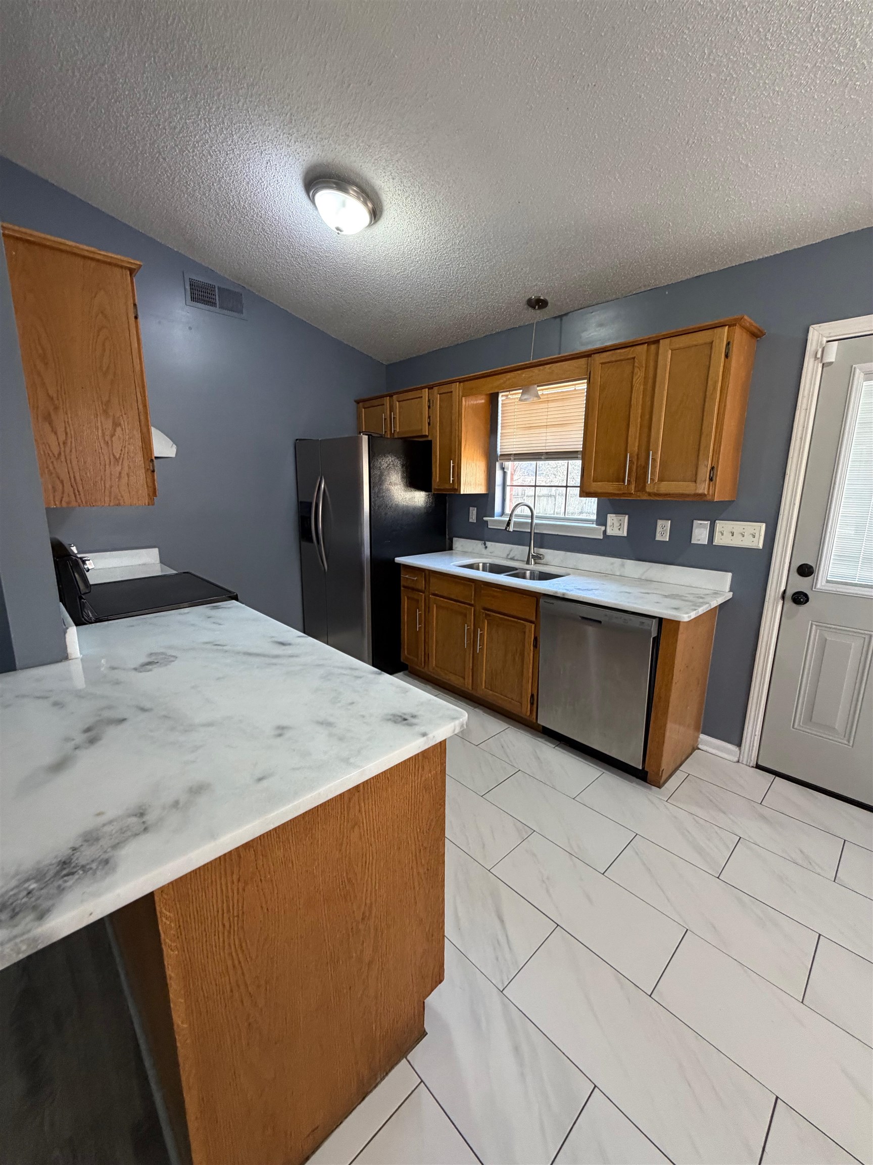 5901 Garden Ridge Drive Millington, TN 38053 - Photo 3 of 15 a kitchen with stainless steel appliances granite countertop a sink and a refrigerator