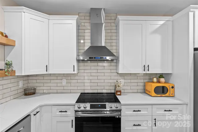 a kitchen with granite countertop a stove a sink and a microwave