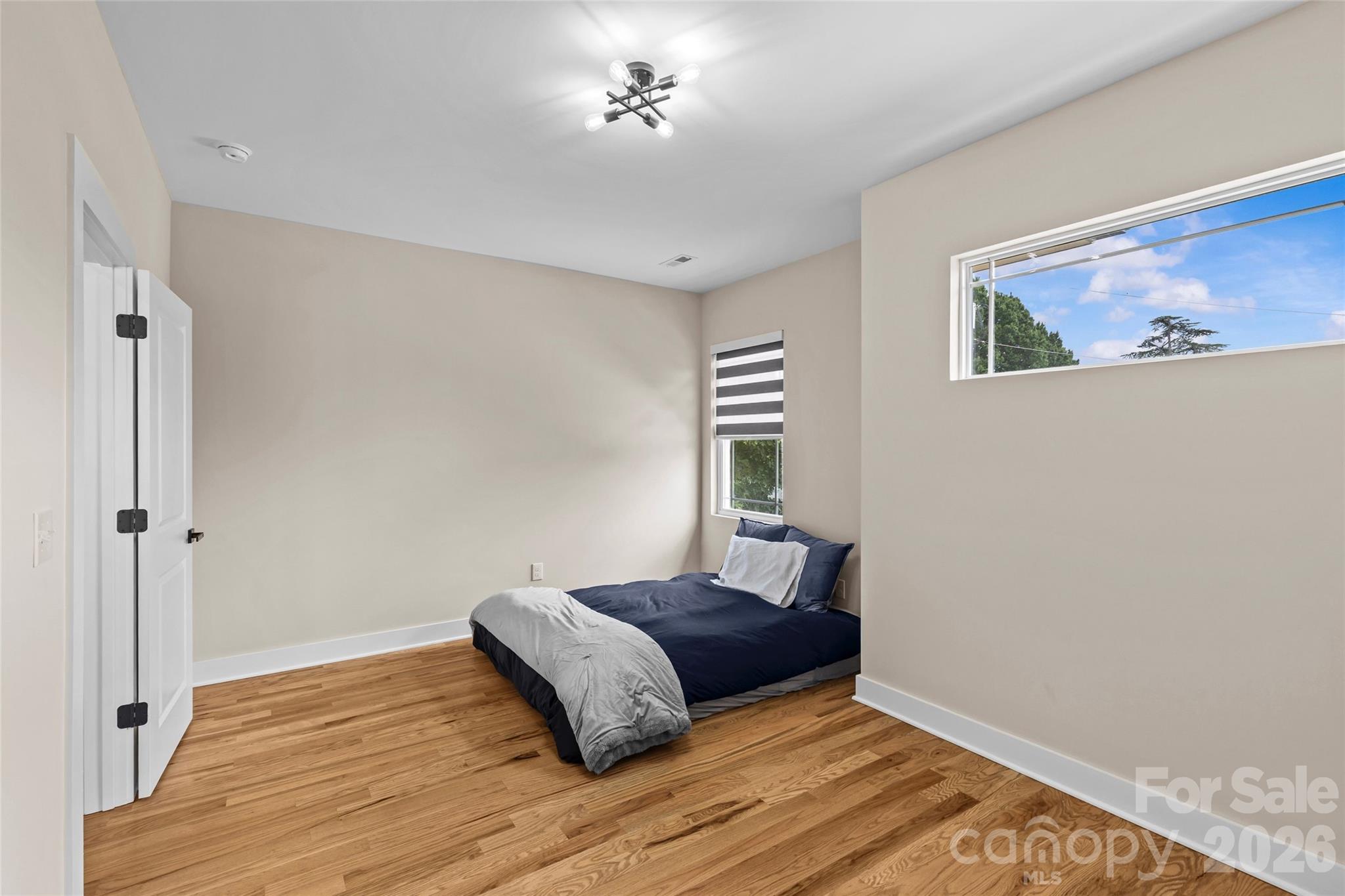 8925 Harrisburg Road Charlotte, NC 28215 - Photo 25 of 37 a bedroom with a bed and wooden floor