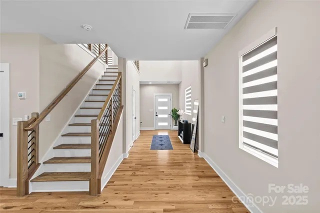 a view of a hallway with wooden floor and windows