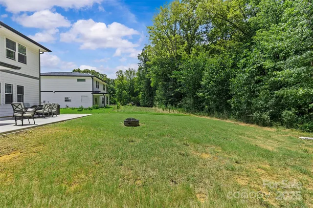 a backyard of a house with table and chairs