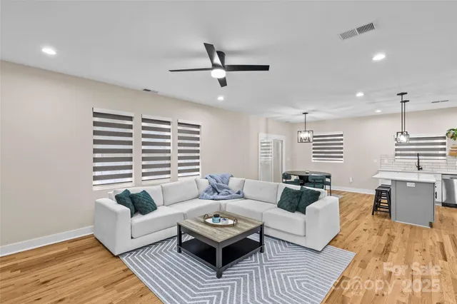 a living room with furniture and a wooden floor