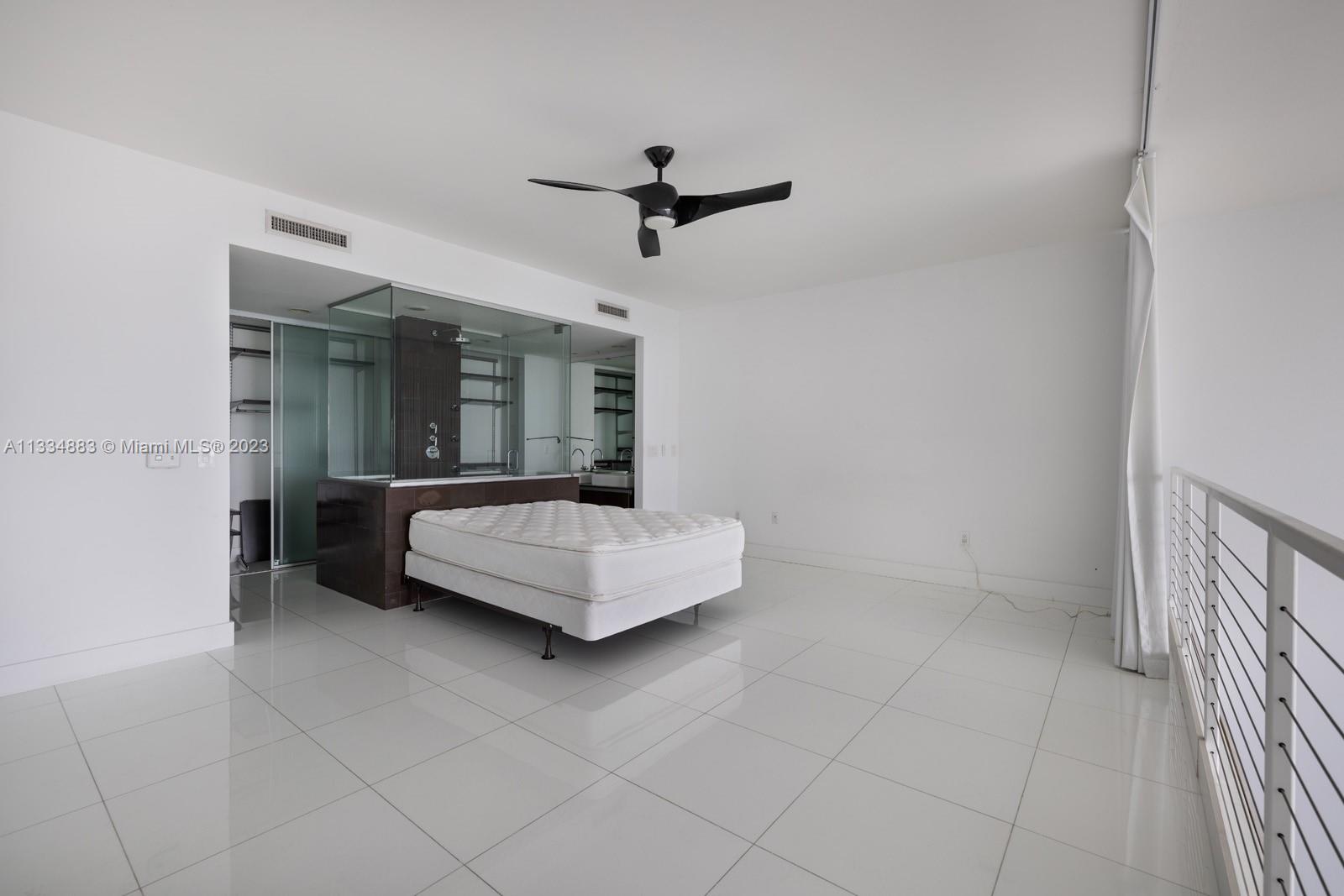 1040 Biscayne Boulevard, Unit 2402 Miami, FL 33132 - Photo 13 of 25 a spacious bedroom with a bed and a walk in closet