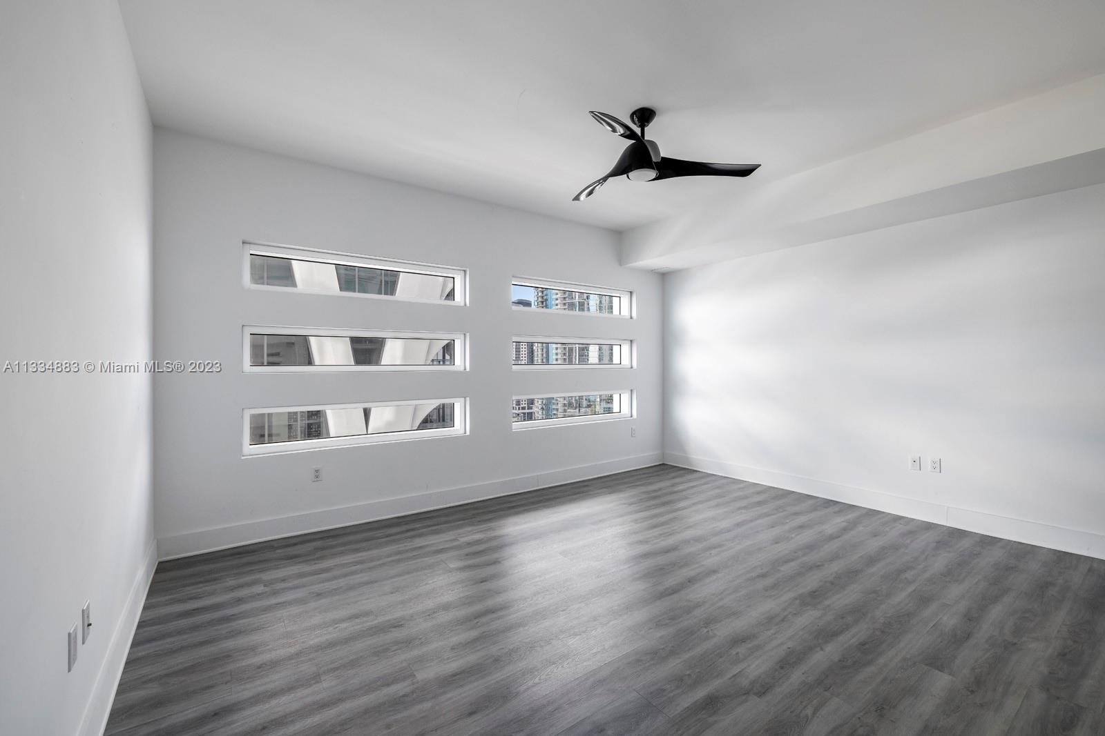 1040 Biscayne Boulevard, Unit 2402 Miami, FL 33132 - Photo 17 of 25 a view of an empty room with a window and wooden floor