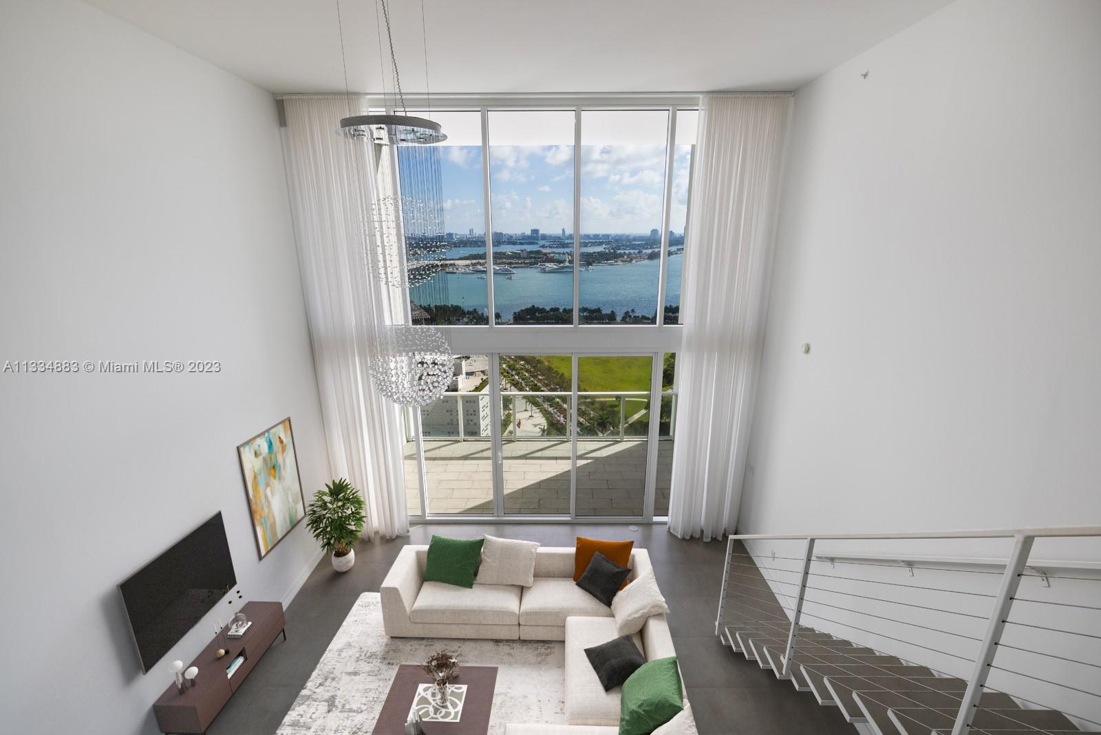 1040 Biscayne Boulevard, Unit 2402 Miami, FL 33132 - Photo 2 of 25 a living room with furniture and a window