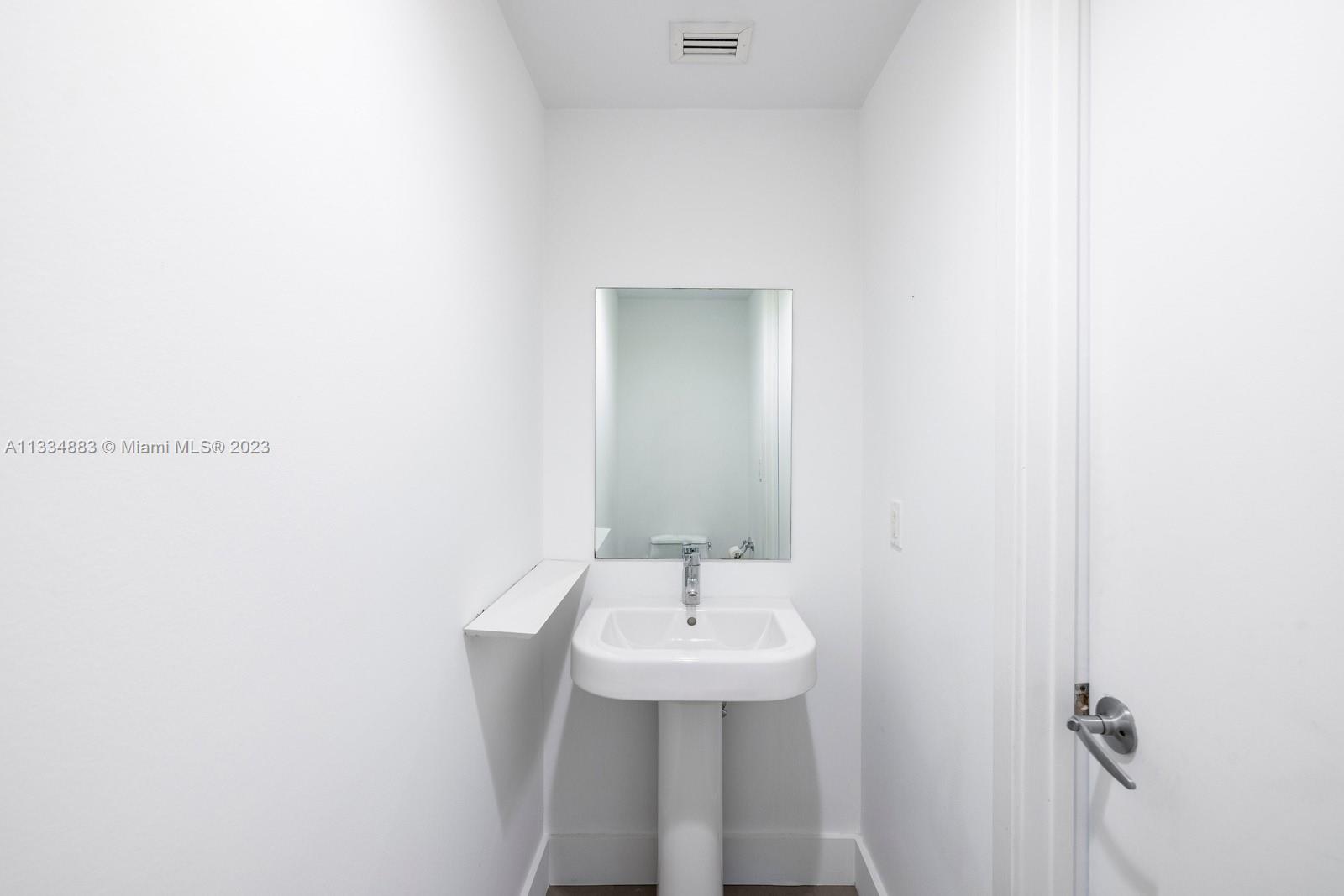 1040 Biscayne Boulevard, Unit 2402 Miami, FL 33132 - Photo 21 of 25 a bathroom with a sink a mirror and a toilet