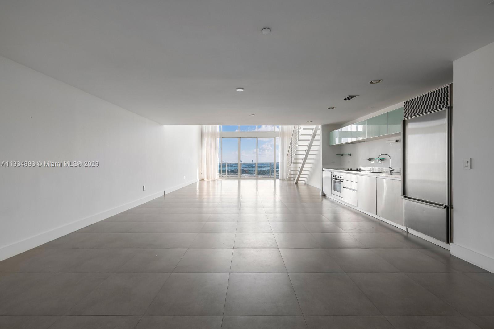 1040 Biscayne Boulevard, Unit 2402 Miami, FL 33132 - Photo 6 of 25 a view of a kitchen with refrigerator and an empty room