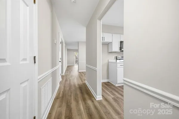a view of a hallway with wooden floor and staircase