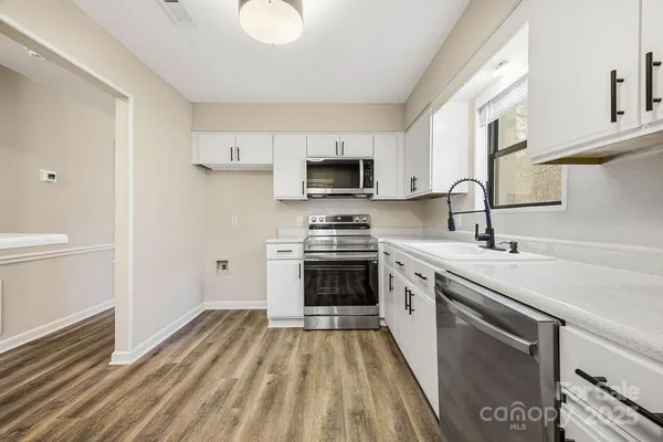 a kitchen with a sink stove and microwave