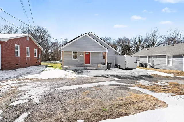 a front view of a house with a yard covered in snow