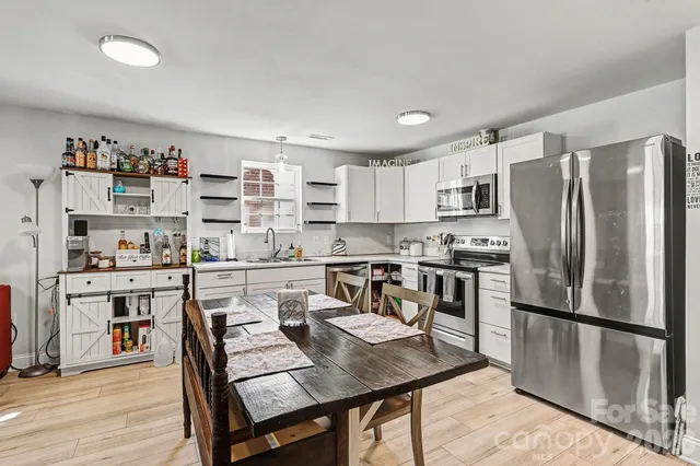 a kitchen with stainless steel appliances a stove a sink a microwave and cabinets