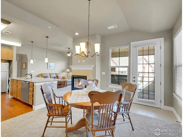 a dining room with furniture a chandelier and wooden floor