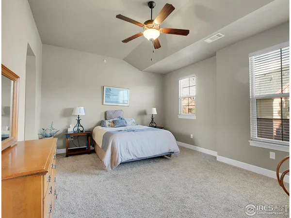 a spacious bedroom with a bed and a chandelier