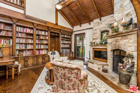 a living room with fireplace furniture and a rug