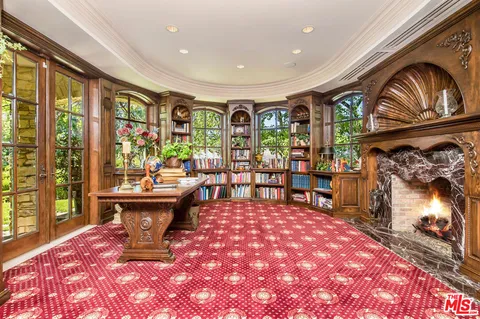 a living room with a fireplace furniture and a large window