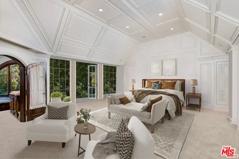 a bedroom with furniture and large windows