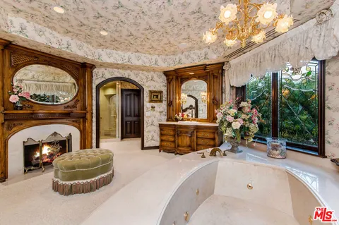 a living room with furniture a fireplace and a floor to ceiling window