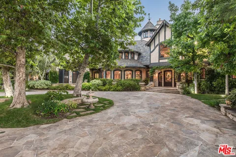 a front view of a house with a yard and fountain