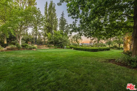a front view of a house with yard and green space